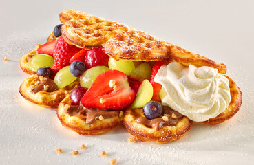 Waffel eingeklappt mit gemischtem Obst mit Erdbeeren Heidelbeeren Trauben Schokoladenpudding und Sahnetupfer mit Puderzucker, Crepes, 