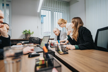 Business team members working together on a project at an office table with technology and...