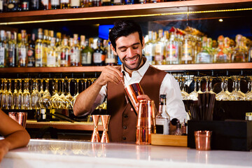 Smiling bartender mixes a cocktail behind a well-stocked bar in a vibrant nightclub, showcasing professional drink service and nightlife ambiance for hospitality and bar business promotion.