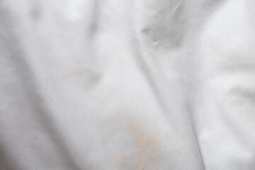 Obraz premium White background with spots with shadows and folds of fabric for design and backing, dirty white fabric