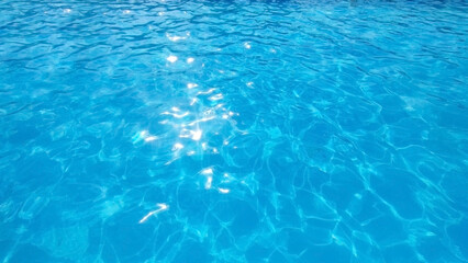 Blue background, water with reflection of the sun's rays