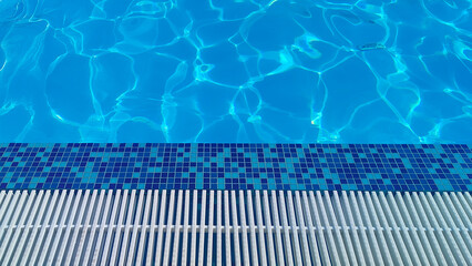 Blue background, pool edge and blue water with sunshine