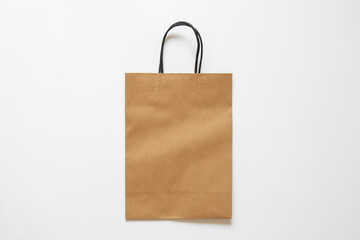Brown paper bag on white background as mockup, kraft paper packaging, top view
