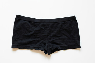 Black women's panties in the form of shorts on a white background, top view, cotton material, underwear