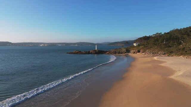 Quiet Sandy Beach Near The Fazo baliza do Lago Lighthouse In Muxia, A Coru&ntilde;a, Spain. - aerial shot