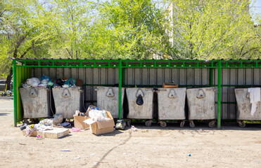 garbage bins full of waste under the roof outside