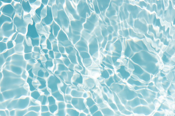 Blue water with ripples on the surface. Defocus blurred transparent blue colored clear calm water surface texture with splashes and bubbles. Water waves with shining pattern texture background.