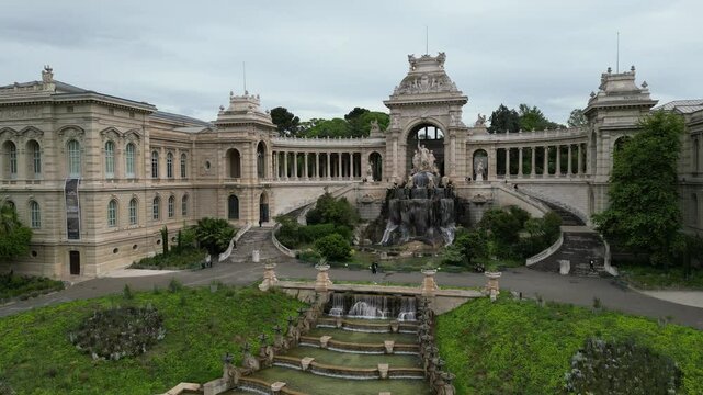 Aerial view of Palais Longchamp in Marseille, France. The historic building, ornate architecture, a central fountain, gardens. The scene captures the beauty of the structure	
