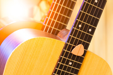 close up pink pick on acoustic guitar, music background