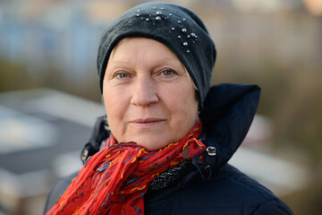 Autumn portrait of a cheerful middle-aged woman in black jacket.