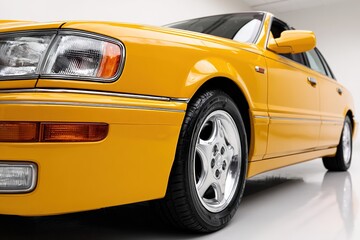 Fototapeta premium Yellow car at three-quarter angle, high-resolution photo with crisp details on clean white background.