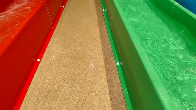 A teenage child steps off a brightly colored waterslide, a place to relax and have fun on the water
