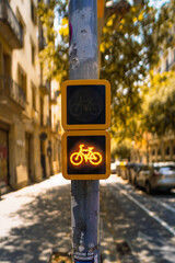 Yellow bicycle traffic signal light on city street pole