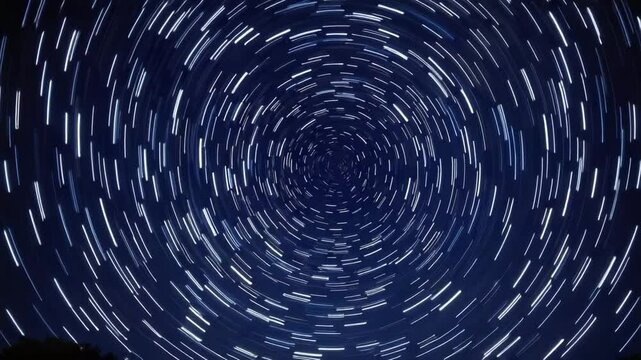 Star trails creating a circular pattern in a night sky landscape  