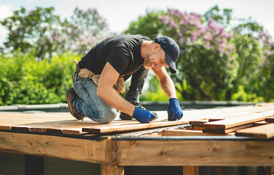 Handyman worker making patio outside close to a pool
