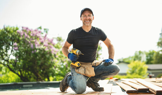 Handyman worker making patio outside close to a pool