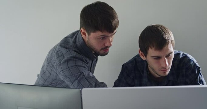 Team adult male engineer collaborate on robotic hand project using AI code solutions machine learning at tech workspace. Artificial intelligence interface, collaboration support prototype development.