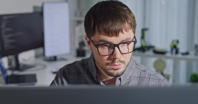 Closeup young adult male freelance developer typing write prompt AI bot app program nomad terminal with coding at office. Artificial intelligence dashboard, robotics, user interface, machine learning.