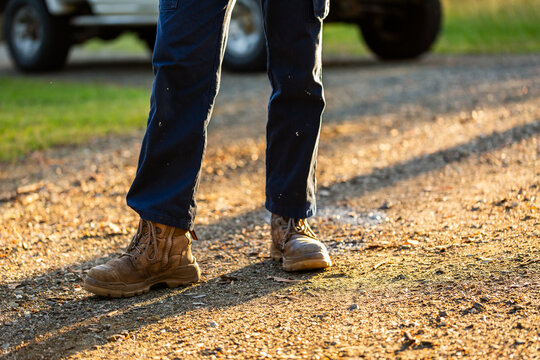 Young man wearing sturdy workwear boots standing on gravel driveway