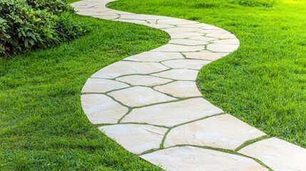 Curved hardscaping stone pathway winding through lush green grass in a landscaped garden setting with natural outdoor lighting