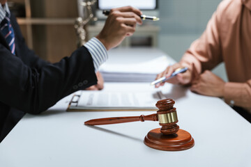 Close up of hands Lawyers explain and discuss matters of law and contract agreement to clients discuss for prepare for the trial. gavel hammer and scales of justice.