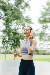 Jogging woman in athletic wear urban park fitness activity green environment dynamic viewpoint healthy lifestyle