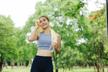 Fitness enthusiast cooling down after workout park photo greenery close-up health and wellness