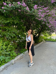 A young girl stands under a tree covered with flowers