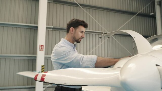 Aircraft engineer inspecting propeller with tablet in slow motion