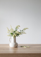 white lilac flowers in vase on wooden table