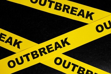 Disease outbreak warning concept. Yellow barricade tape with word in dark black background.