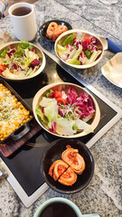 Korean barbecue table setting with fresh salad, kimchi, and corn cheese