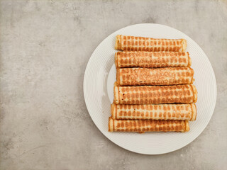 Waffle rolls presenting on white plate and marble table
