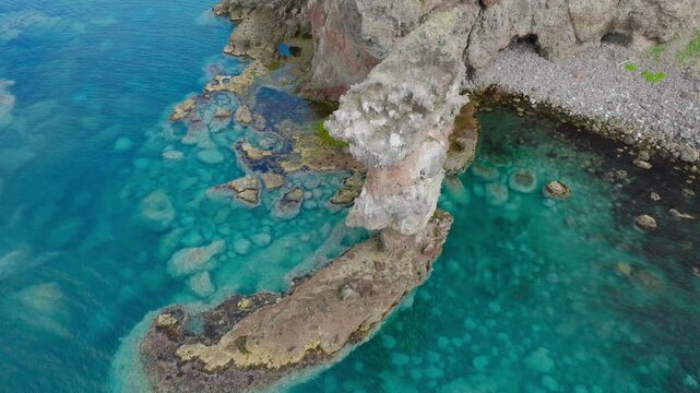 Aerial fly close to clean ocean cliff revealing sea boton in Shakotan Hokkaido Japan, summer nature travel environment