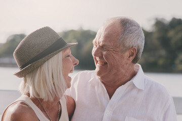 happy senior couple by the water