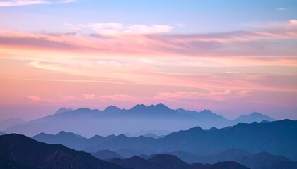 Dreamy cotton-candy sky with pearlescent clouds above a blurred silhouette of soft mountains at dusk