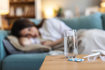Woman, sick and thinking on sofa with blanket, anxiety and falling asleep for recovery. Mature person, tired and allergies in home in flu season, break up depression and mental health burnout or sad.