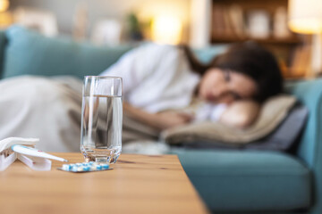 Depression, anxiety and medicine with a suicide woman lying on her bed in the bedroom of her home alone. Mental health, help and pills with a female suffering from a psychology disorder in her home.