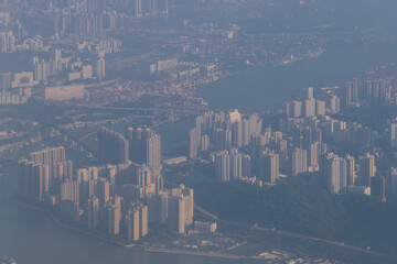 Aerial view from a Cathay Pacific plane over the various Islands of Hong Kong and the financial district with many high-rise skyscrapers creating a dense country