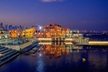 Naklejka premium Doha, Qatar - March 20, 2025: Colorful shopping villa's at old port mina park Qatar with selective focus.