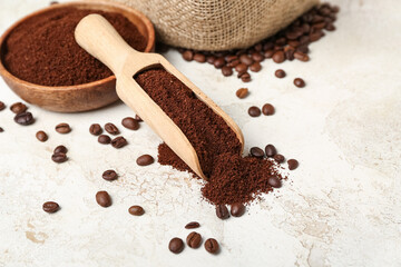 Scoop with bowl of coffee powder and beans on grunge table, closeup