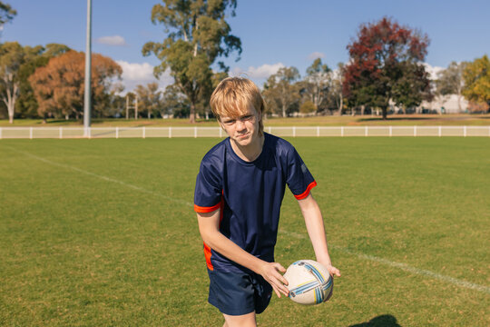 Junior rugby union player practicing ball pass on field