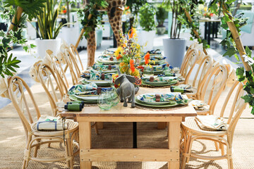 Wedding table setup with zoo floral arrangement. Stylish Dining Table in Greenhouse. Tropical Table Setting with Flowers. A stylish dining table set in a greenhouse, surrounded by lush green plants.