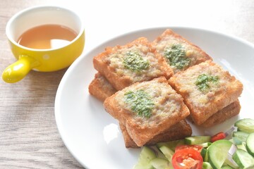 Thai crispy fried pork toast on plate eat couple with pickled vegetable sauce