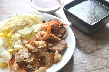 Korean fried slice pork with cabbage and glass noodles on plate dipping spicy sauce couple soup