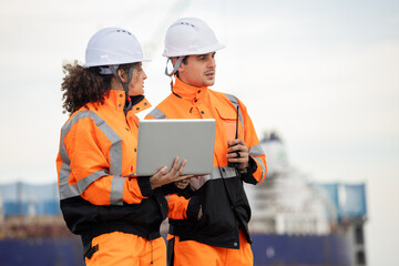 Maritime Safety Engineers Working at Port Terminal with Laptop and Walkie-Talkie, Industrial Engineers Collaborating at Harbor Site, Dock Worker in Safety Uniforms Using Technology for Port Operations