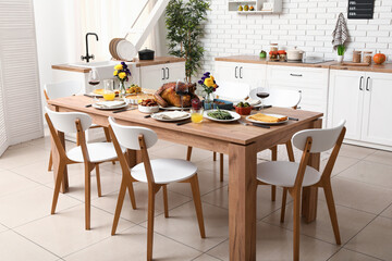Festive dining table with tasty food for Thanksgiving Day in kitchen