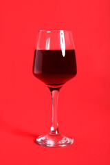 Glass of wine on red background