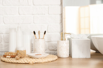 Bath supplies near white brick wall in bathroom