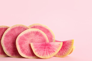 Slices of fresh watermelon radish on pink background